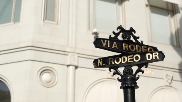 Dünyaca ünlü Rodeo Drive sembolü, Crosstreet tabelası, Beverly Hills kavşağı. Turistik Los Angeles, Kaliforniya, ABD. Zengin zengin yaşam tüketiciliği, lüks markalar ve yüksek sınıf mağazalar konsepti. — Stok video