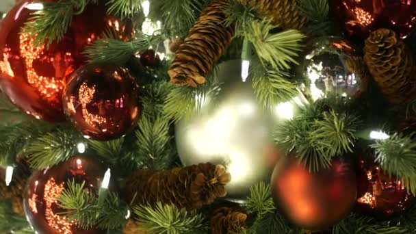 Närbild av festligt inredda utomhus julgran med ljusa röda bollar på suddig gnistrande älva bakgrund. Oskärpa körfältsbelysning, Bokeh effekt. God Jul och God Jul konceptet. — Stockvideo