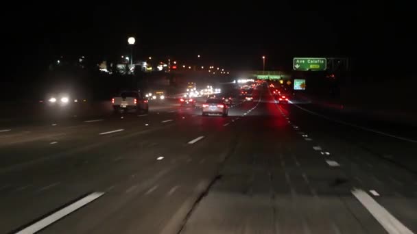 차에서 바라봐. 로스앤젤레스는 밤에 고속도로를 달리느라 바쁩니다. 미국 캘리포니아 주 (州) 간 고속 도로 (Massive Interstate Highway). 고속 도로에서 자동차 운전이 빠르다. 교통 정체와 도시 교통 개념. — 비디오