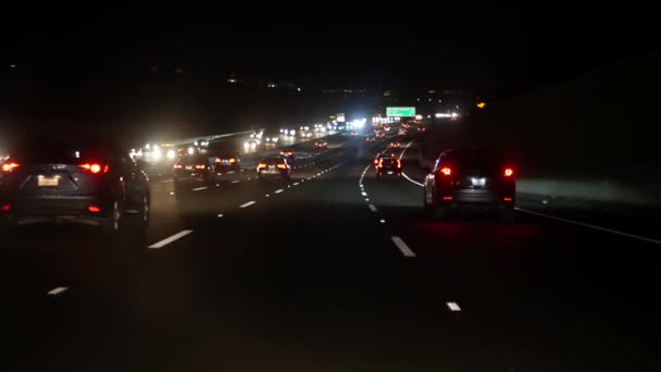 Pohled z auta. Los Angeles, rušná dálnice v noci. Massive Interstate Highway Road v Kalifornii, USA. Auto jede rychle po rychlostních silnicích. Koncept dopravní zácpy a městské dopravy. — Stock video