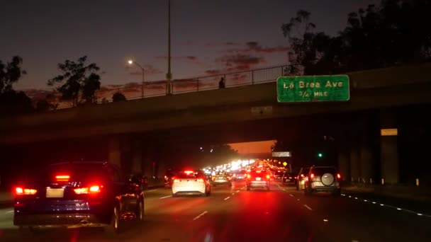 Pohled z auta. Los Angeles, rušná dálnice v noci. Massive Interstate Highway Road v Kalifornii, USA. Auto jede rychle po rychlostních silnicích. Koncept dopravní zácpy a městské dopravy. — Stock video