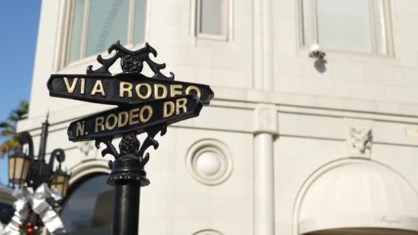 Wereldberoemde Rodeo Drive symbool, Cross Street Sign, kruispunt in Beverly Hills. Toeristisch Los Angeles, Californië, Verenigde Staten. Rijk rijk levensconsumentisme, luxe merken en high-class winkels concept. — Stockvideo