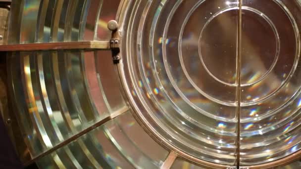 Fresnel lens with brass structure, nautical lighthouse tower. Detail of the glass lantern with rainbow spectrum. System of lamps and lenses to serve as a navigational aid. Old sea searchlight beacon. — Stock Video