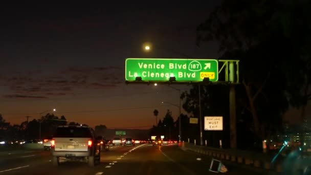 View from the car. Los Angeles busy freeway at night time. Massive Interstate Highway Road in California, USA. Auto driving fast on Expressway lanes. Traffic jam and urban transportation concept. — Stock Video