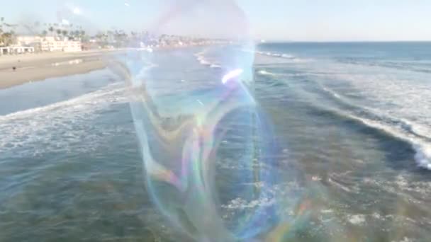 Bulles de savon soufflant sur la jetée de l'océan en Californie, fond d'été flou. Métaphore romantique créative, concept de rêve de bonheur et de magie. Symbole abstrait de l'enfance, fantaisie, liberté — Video