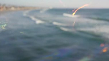 Kaliforniya 'da okyanus rıhtımında sabun köpüğü üflemek, yaz arkaplanını bulanıklaştırmak. Yaratıcı romantik metafor, hayal kurmak mutluluk ve sihir. Çocukluğun soyut sembolü, fantezi, özgürlük