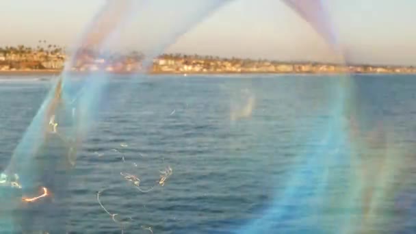 Kaliforniya 'da okyanus rıhtımında sabun köpüğü üflemek, yaz arkaplanını bulanıklaştırmak. Yaratıcı romantik metafor, hayal kurmak mutluluk ve sihir. Çocukluğun soyut sembolü, fantezi, özgürlük — Stok video