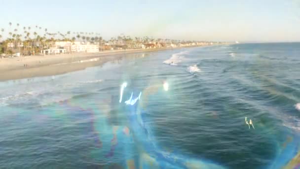 Soffiando bolle di sapone sul molo oceanico in California, sfondo estivo sfocato. Metafora creativa romantica, concetto di sognare felicità e magia. Simbolo astratto dell'infanzia, fantasia, libertà — Video Stock