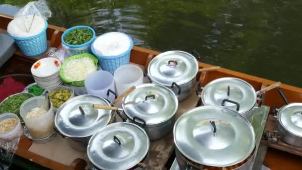 Iconic asian Lat Mayom floating market. Khlong river canal, long-tail boat with bowls of traditional thai cusine streetfood. Top view of siamese spicy street food assortment in wooden canoe for sale — Stock Video