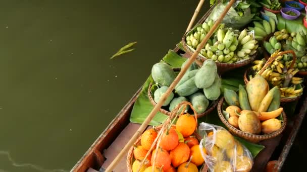 Iconic asian Lat Mayom floating market. Khlong river canal, long-tail boat with tropical exotic colorful fruits, organic locally grown vegetables. Top view of harvest and street food in wooden canoe — Stock Video