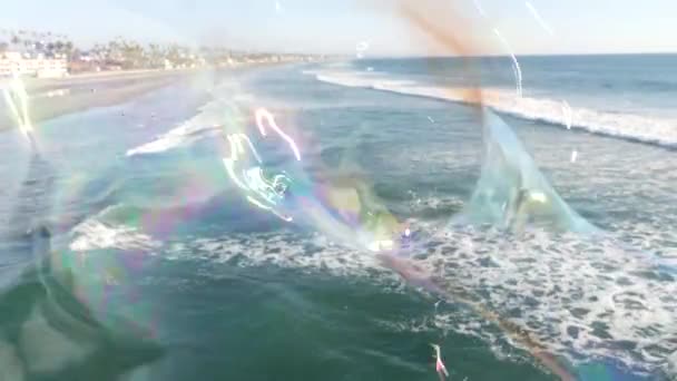 Soffiando bolle di sapone sul molo oceanico in California, sfondo estivo sfocato. Metafora creativa romantica, concetto di sognare felicità e magia. Simbolo astratto dell'infanzia, fantasia, libertà — Video Stock