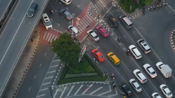 Verkehr auf der Kreuzung auf der Straße. Von oben fahren moderne Autos und Motorräder auf einer Straßenkreuzung im Zentrum von Bangkok, Thailand — Stockvideo