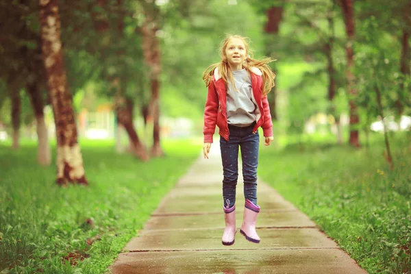 春の雨の下で遊ぶ女の子 — ストック写真