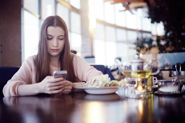 Young woman using phone at cafe — Stock Photo, Image