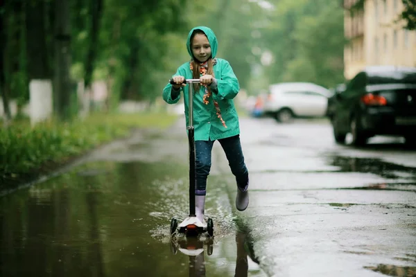 Chica jugando bajo lluvia de primavera — Foto de Stock