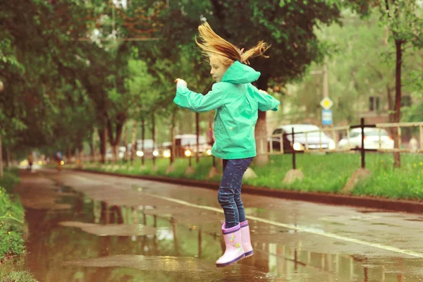 Chica jugando bajo lluvia de primavera — Foto de Stock