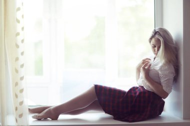 genç kadın bir pencere üzerinde yalan