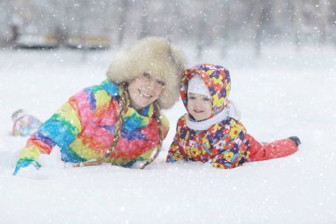  kadın ve kışın oynayan bir çocuk 