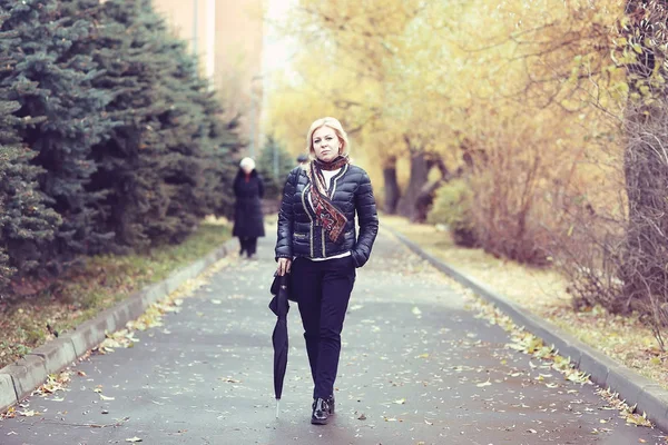 Kvinna promenader i höstparken — Stockfoto