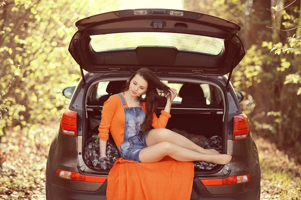 Mulher sentada na bagageira do carro — Fotografia de Stock