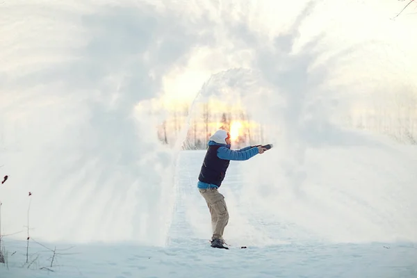 Homem jogando neve ao pôr do sol — Fotografia de Stock