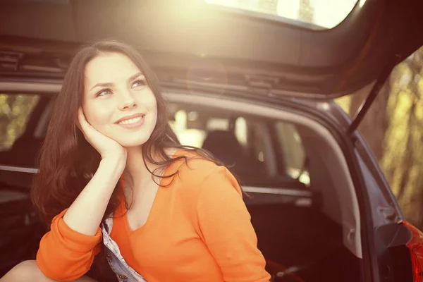 Mulher sentada na bagageira do carro — Fotografia de Stock