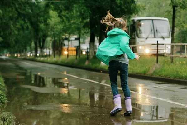 Jente som leker under vårregnet – stockfoto