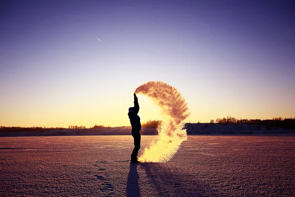 Uomo che lancia neve al tramonto — Foto Stock