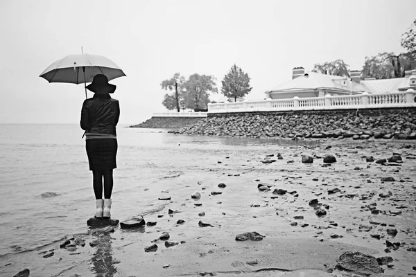 Vrouw met een paraplu aan zee — Stockfoto