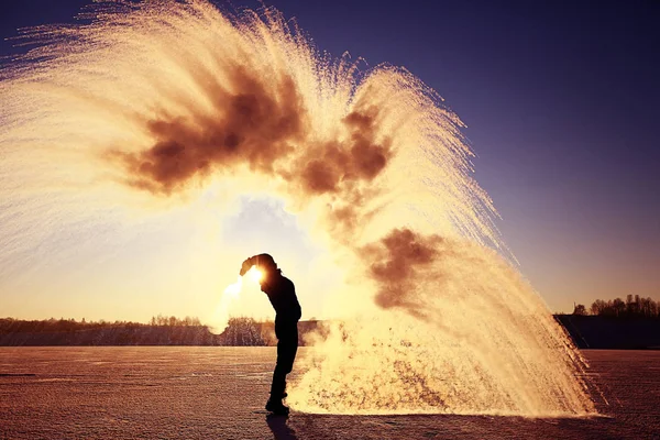 Un homme jette de la neige au coucher du soleil — Photo