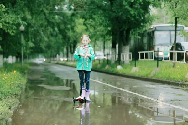 Söt flicka under våren regn — Stockfoto