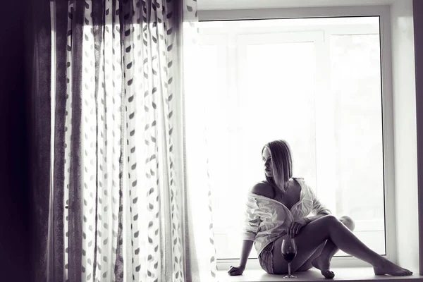 Молодая женщина, лежащая на окне — стоковое фото