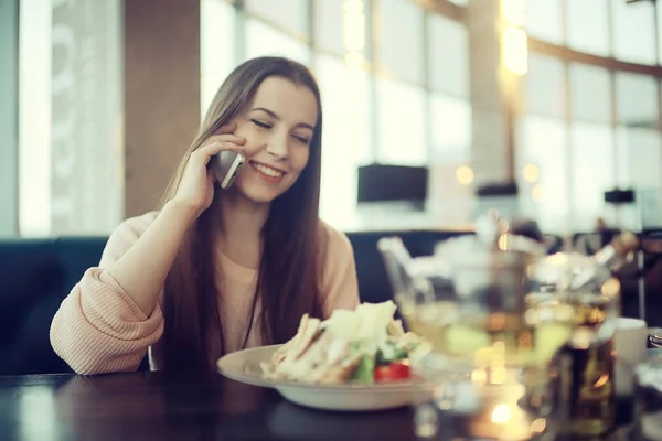 Молодая женщина по телефону в кафе — стоковое фото