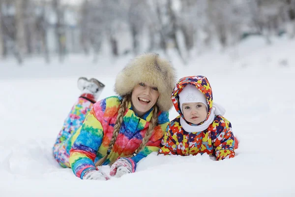 Девушка с мамой в снежном парке — стоковое фото