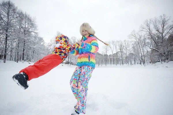 Chica con madre en el parque cubierto de nieve —  Fotos de Stock