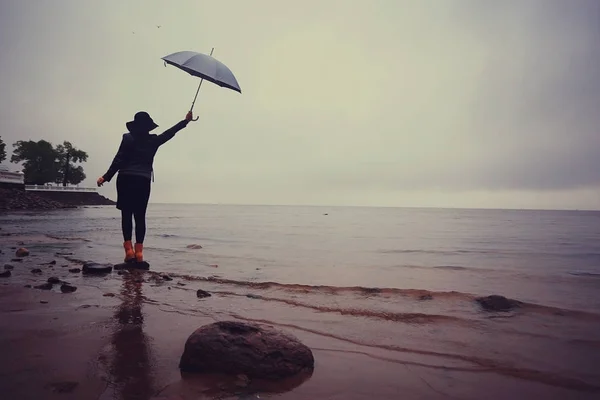 Женщина с зонтиком идет после дождя — стоковое фото