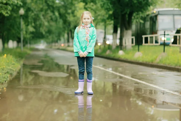 Söt flicka under våren regn — Stockfoto