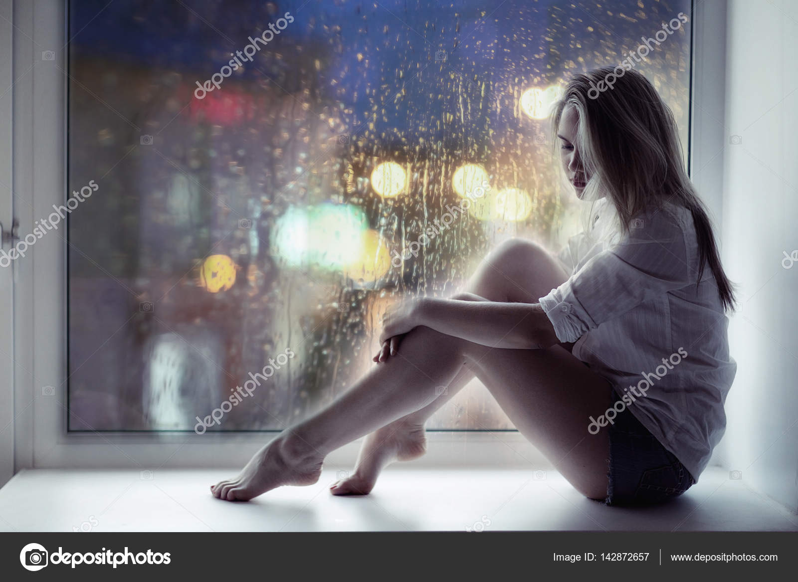 Sad girl sitting on windowsill Stock Photo by ©xload 142872657