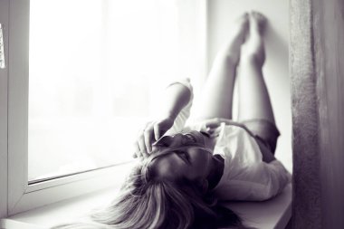 genç kadın bir pencere üzerinde yalan