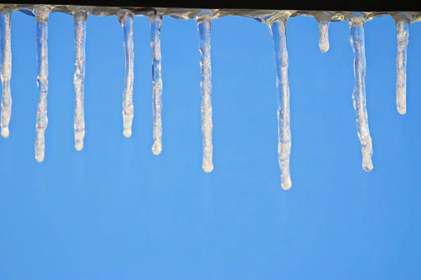 Icicles over blue clear sky — Stock Photo, Image