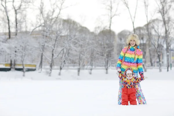 Vrouw en een kind spelen in de winter — Stockfoto