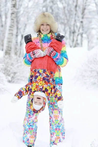 Mulher e uma criança brincando no inverno — Fotografia de Stock