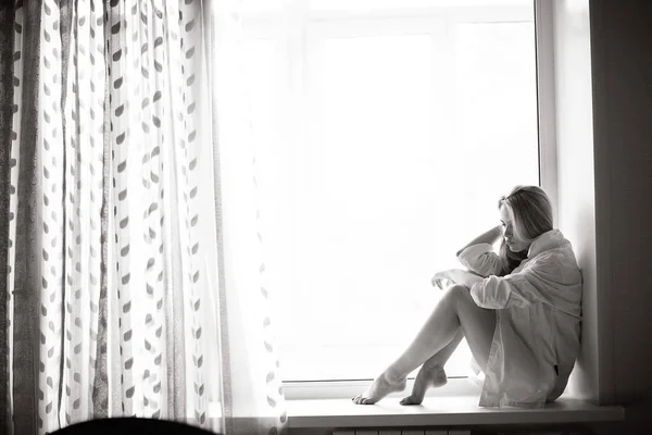 Fiatal nő ül ablakpárkány — Stock Fotó