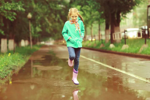 Jente som leker under vårregnet – stockfoto
