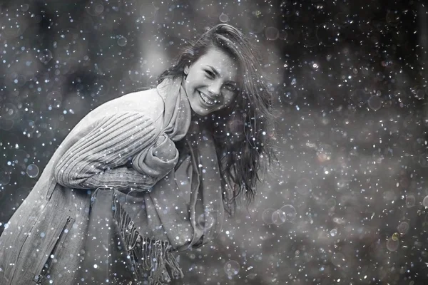 Jeune fille avec des flocons de neige dans l'air — Photo