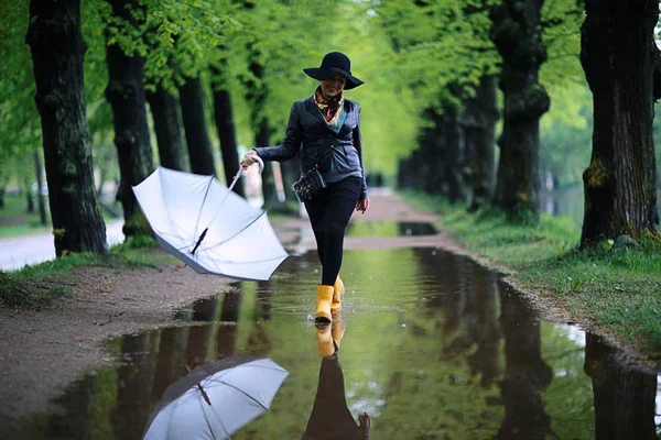 Woman running in street with puddles — Stock Photo, Image