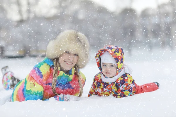 Kadın ve kışın oynayan bir çocuk — Stok fotoğraf