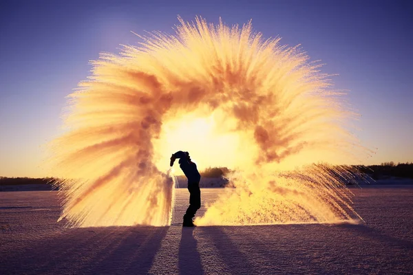 Un homme jette de la neige au coucher du soleil — Photo