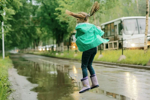 春の雨の下で遊ぶ女の子 — ストック写真
