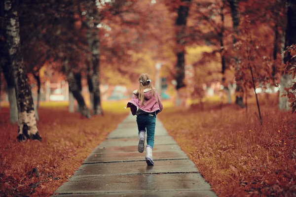 Girl running in the autumn park 